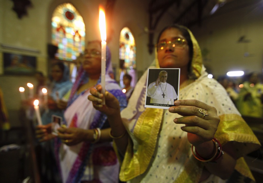 Women hold candles and pictures of newly elected Pope Francis during a Mass of thanksgiving in his honor at a church on March 17 in Kolkata, India. PHOTO: CNS/Rupak De Chowdhuri, Reuters