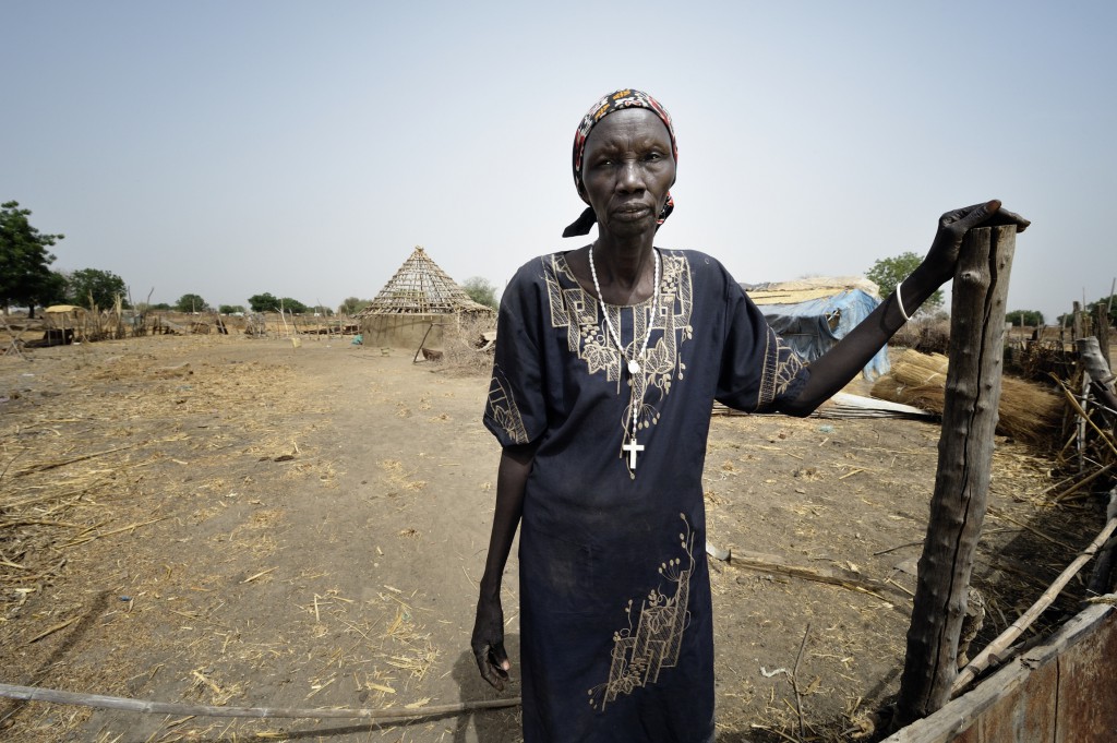 Bruna Maloal, a 63-year old Catholic catechist, stands at the gate to her home in Abyei, a town at the center of the contested Abyei region along the border between Sudan and South Sudan. Her home was looted and burned in 2011 when soldiers and militias from Sudan swept through the area, chasing out Maloal and tens of thousands of others. PHOTO: CNS/Paul Jeffrey