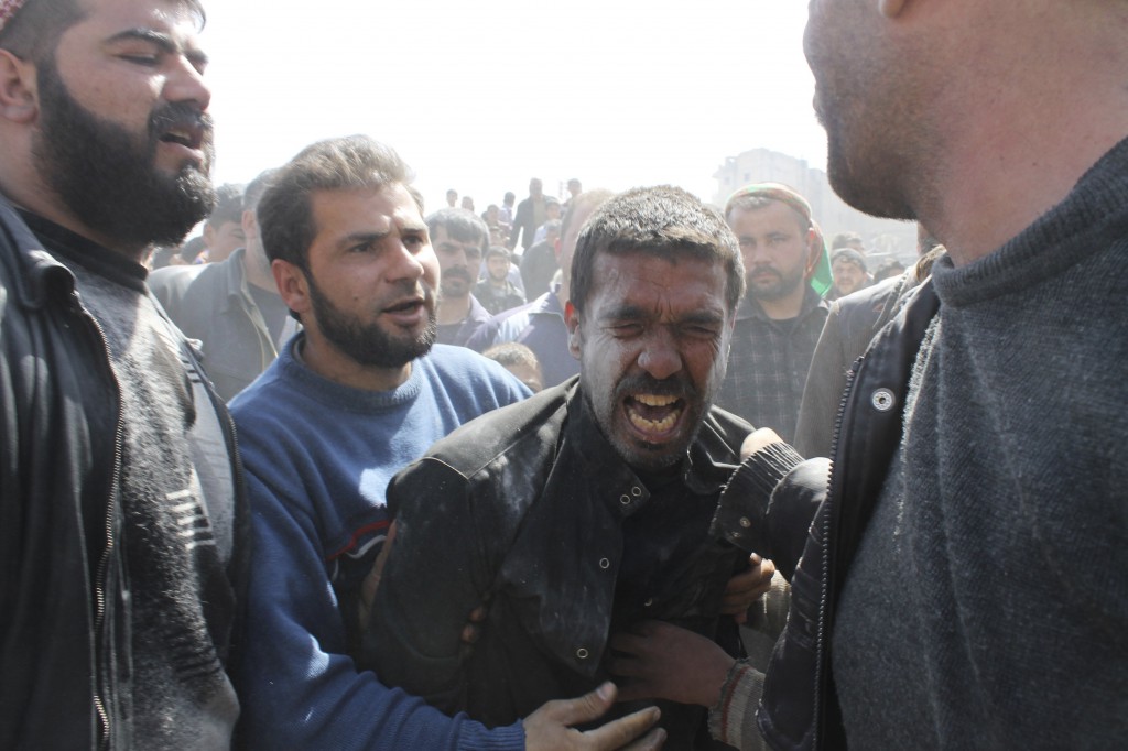 A man mourns the death of relatives while people search for casualties under the rubble at a site hit by what activists said was an airstrike on March 30 in Aleppo, Syria. In Easter messages, Catholic patriarchs in the Middle East as well as Pope Francis highlighted the need for an end to the war in Syria. PHOTO: CNS/Ziad Rev, Reuters