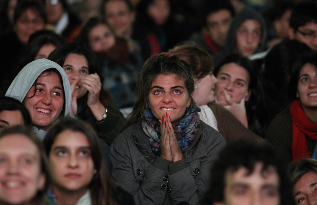 A young woman reacts as she and others watch a televised broadcast on March 19 of the inaugural Mass of the pontiff on a giant screen outside of the Metropolitan Cathedral in Buenos Aires, Argentina. PHOTO: CNS/Marcos Brindicci, Reuters