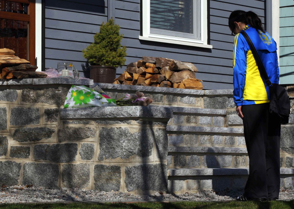 Boston Marathon runner Megan Cloke pauses after leaving flowers on the doorstep of 8-year-old Martin Richard's home in the Dorchester neighborhood of Boston April 16. The boy, a former student at Pope John Paul II Catholic Academy, was one of three people killed when two bombs exploded in the crowded streets near the finish line of the marathon the previous day. PHOTO: CNS/Brian Snyder, Reuters