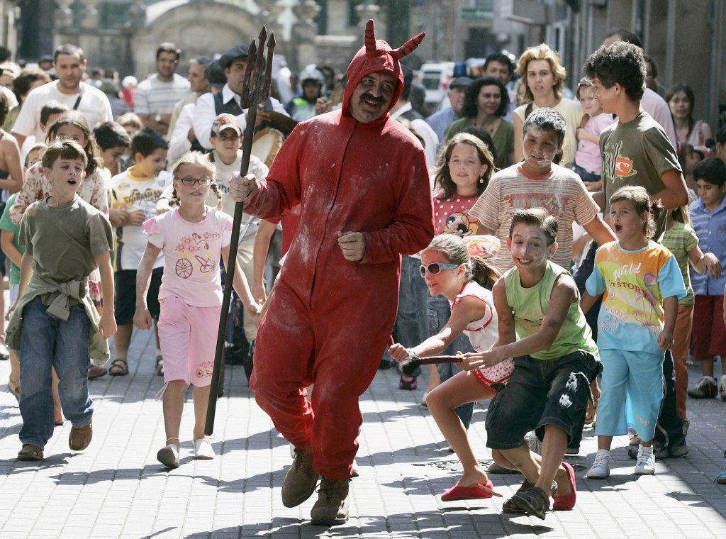 Children chase a man dressed as a devil during a local festival called "Fiesta del Demonio" (Festival of Demons) in Pontevedra, Spain. PHOTO: CNS/Miguel Vidal, Reuters