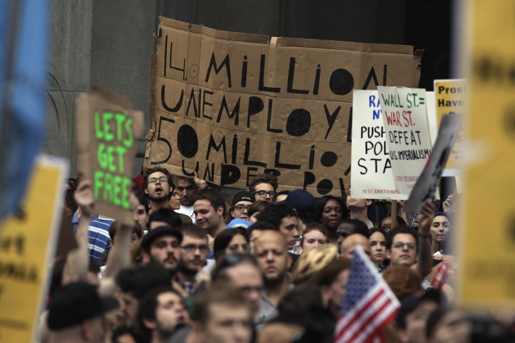 Demonstrators from the Occupy Wall Street campaign hold signs in 2011 as a protest march enters the courtyard near the New York Police Department headquarters. PHOTO: CNS/Lucas Jackson, Reuters