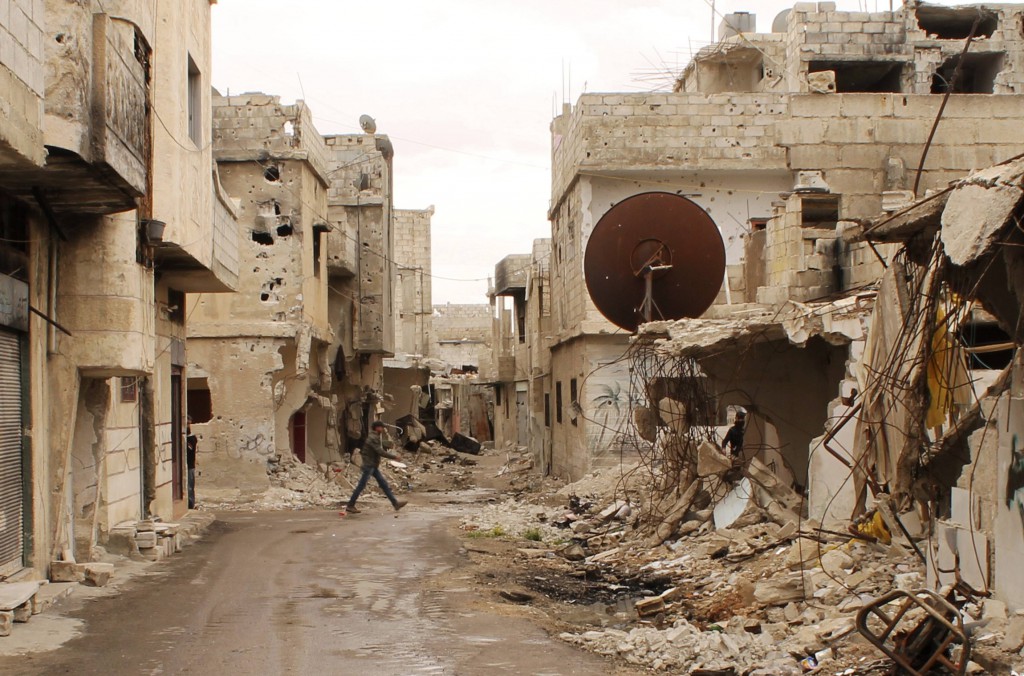 A member of a Free Syrian Army walks past destroyed buildings and debris in Deraa April 17. Lebanon's Maronite Catholic patriarch and Syria's Greek Orthodox patriarch called for the release of two Orthodox bishops kidnapped in Syria. PHOTO: CNS/Thaer Abdallah, Reuters