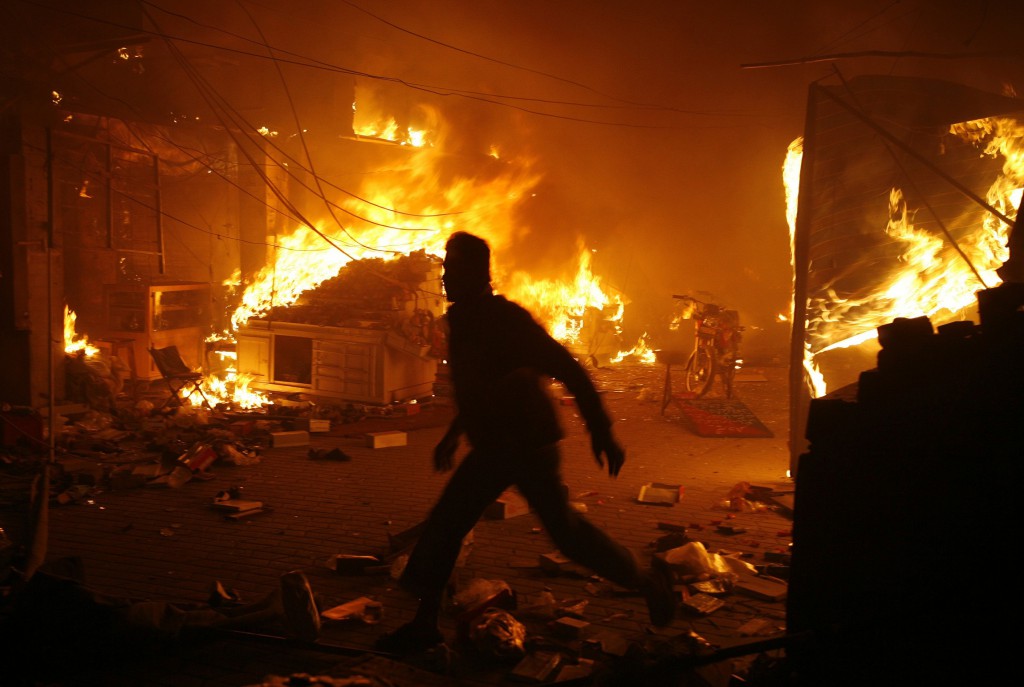 A man runs past a blaze on Dec. 7 after a bomb explosion at a market in Lahore, Pakistan. PHOTO: CNS/Mohsin Raza, Reuters