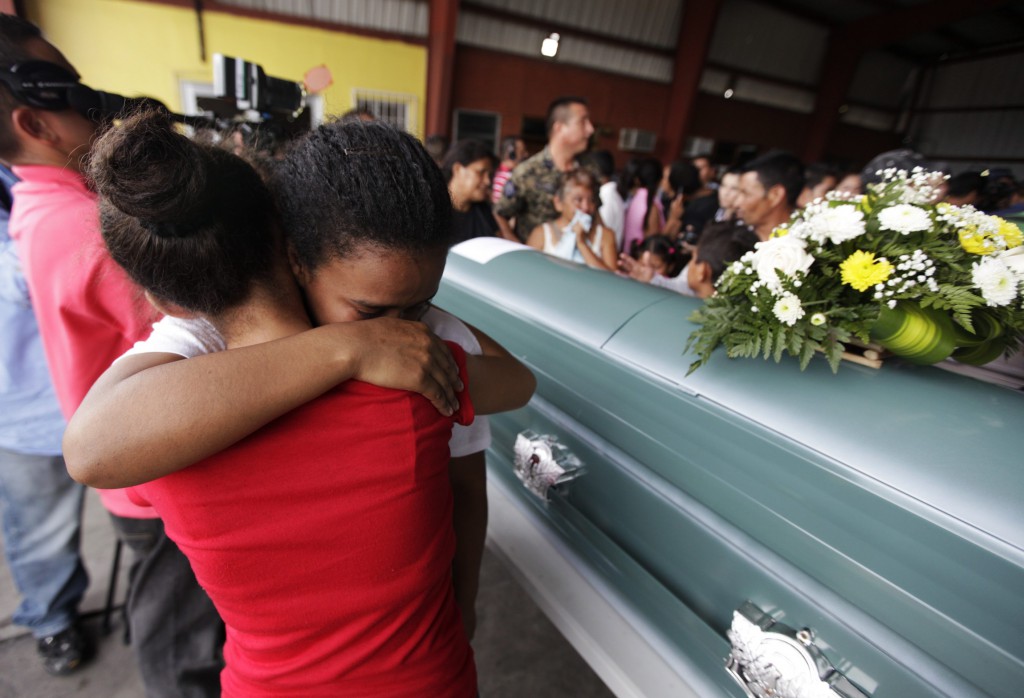 People embrace while standing next to the coffin of a victim of a train derailment in San Pedro Sula, Honduras, Aug. 27. The Mexican bishops' ministry for people on the move called for prayer, reflection and action after the train carrying northbound Central Americans derailed in southern Mexico, killing 11 migrants. PHOTO: CNS/Jorge Cabrera, Reuters