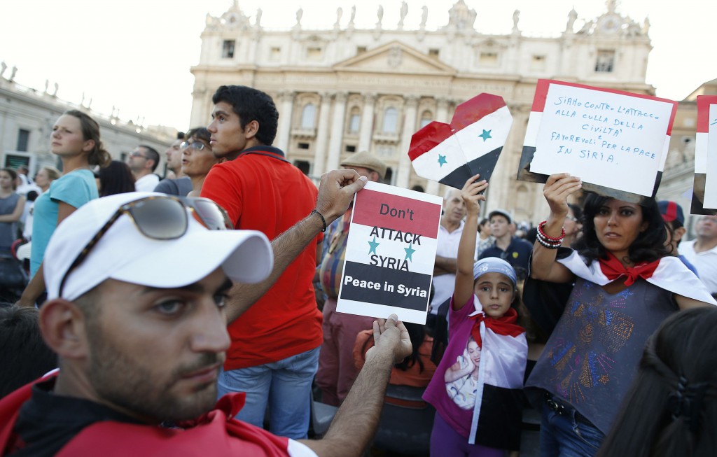 People from Syria hold up signs before a prayer vigil led by Pope Francis in St. Peter's Square at the Vatican Sept. 7. The pope called for the worldwide day of fasting and prayer for peace in Syria, the Middle East and the world. PHOTO: CNS/Tony Gentile, Reuters