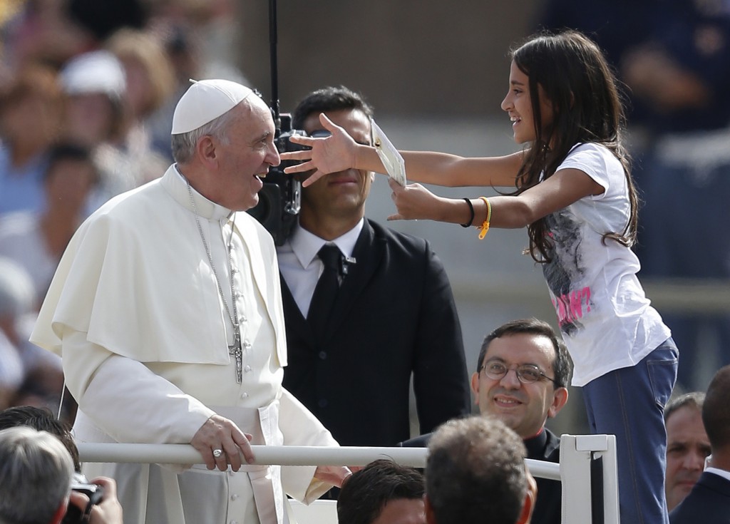 A girl holds a letter as she greets Pope Francis as he arrives to lead his general audience on Sept. 11 in St. Peter's Square at the Vatican. PHOTO: CNS/Paul Haring