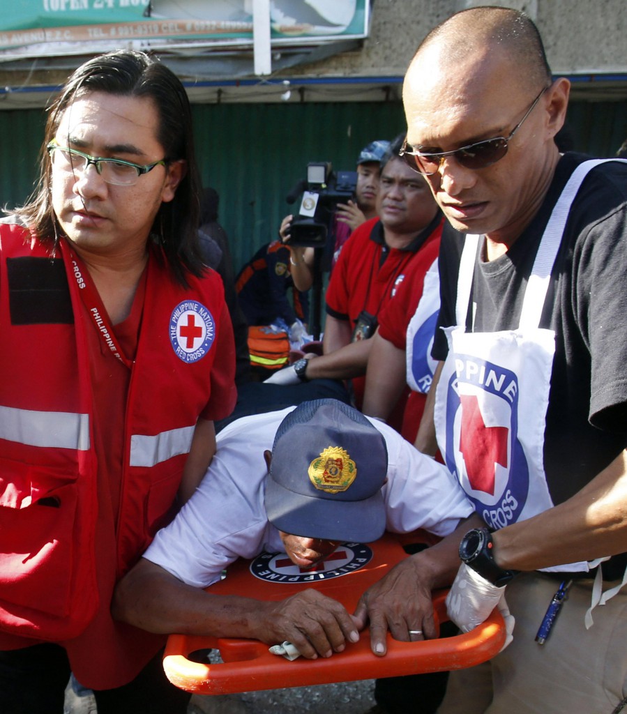 Philippine Red Cross personnel carry a wounded hostage rescued from rebels belonging to the Moro Islamic l Liberation Front in Zamboanga, Philippines Sept. 13. Bishops in southern Philippines have condemned the rebels' use of hostages as human shields in gunfights with government troops.  PHOTO: CNS/Erik De Castro, Reuters