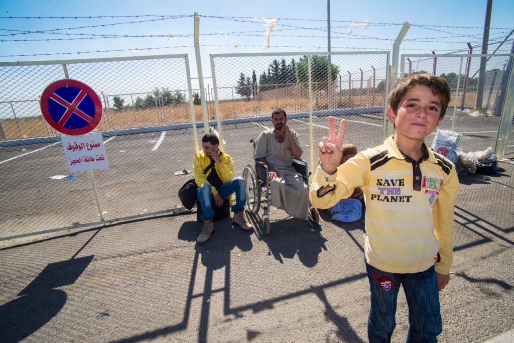 A Syrian refugee boy flashes a peace sign along the border in Kilis, Turkey, in mid-September. More than 1 million Syrian refugees are under 18, about 740,000 under 11, according to the U.N. High Commissioner for Refugees. PHOTO: CNS/Michael Swan, The Catholic Register