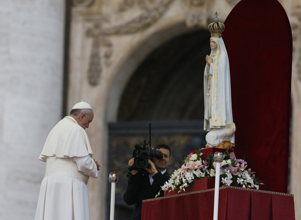 Pope Francis prays in front of the original statue of Our Lady of Fatima during a Marian vigil on Oct. 12 in St. Peter's Square at the Vatican. PHOTO: CNS/Paul Haring