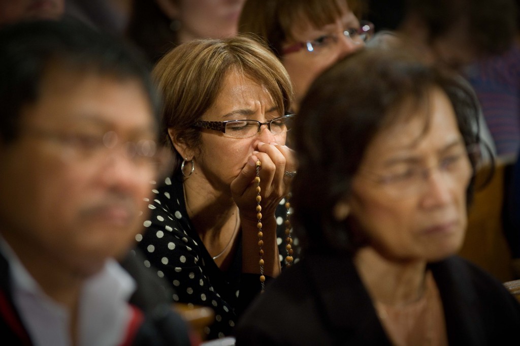 A woman prays the rosary Oct. 12 at the Basilica of the National Shrine of the Immaculate Conception in Washington. Worshippers gathered at the shrine for a global rosary as Catholics participated simultaneously in Rome and at 10 Marian shrines around the world, including Argentina, Poland, Japan, Israel, Mexico, Kenya, Belgium, India and France. PHOTO: CNS/Matthew Barrick