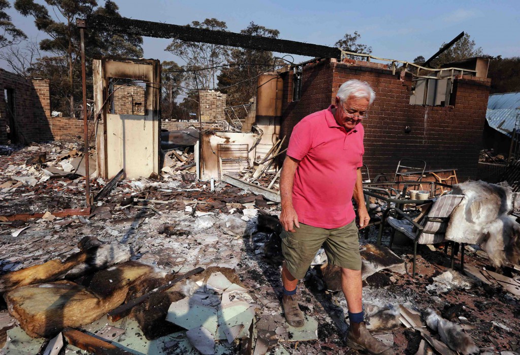 Alan Seaman walks through the remains of his home on Oct. 21 that was destroyed by a bush fire in the Blue Mountains suburb of Winmalee, Australia.  PHOTO: CNS/David Gray, Reuters