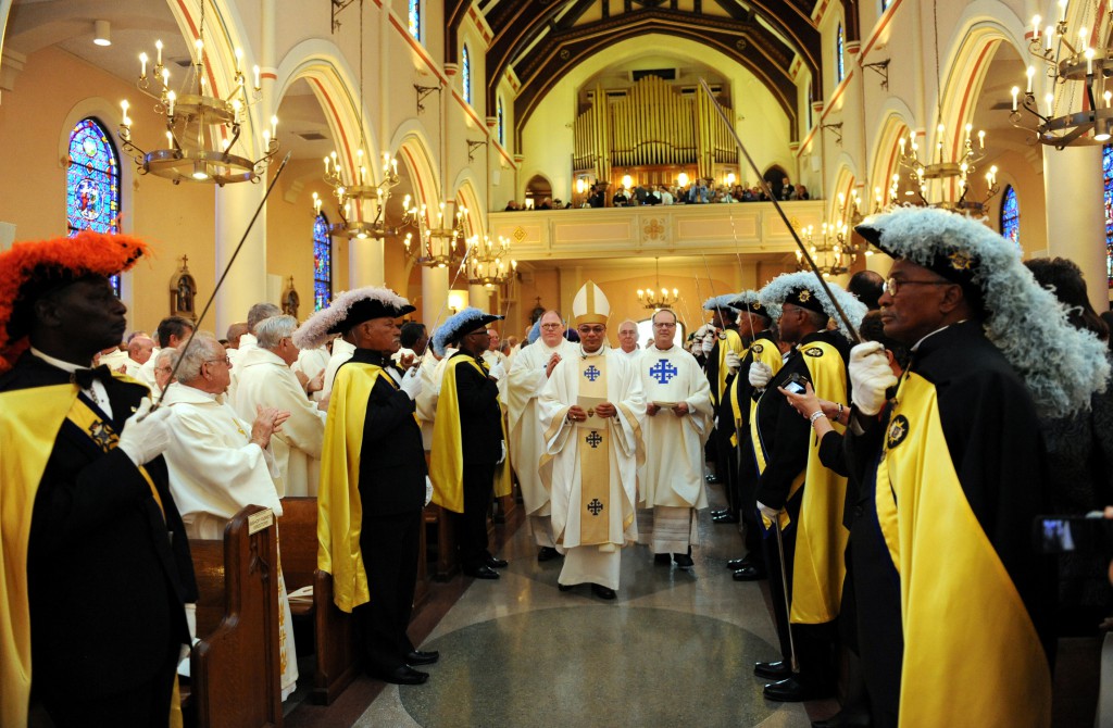 Bishop Shelton J. Fabre processes into the Cathedral of St. Francis de Sales in Houma-Thibodaux, La., flanked by the Knights of Peter Claver and Knights of Columbus honor guard, at the start of his Oct. 30 installation Mass. Bishop Fabre, 49, who has been a New Orleans auxiliary since 2006, succeeds Bishop Sam G. Jacobs, 75, who retired after  heading the Houma-Thibodaux Diocese since 2003. PHOTO: CNS/Lawrence Chatagnier, Bayou Catholic