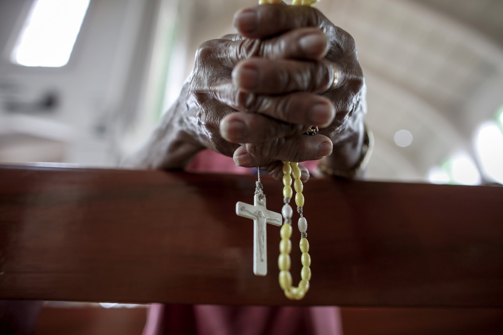 A worshipper holds a rosary Nov. 24 inside the Basilica of the Holy Child in Tacloban, Philippines. Filipinos begin Christmas preparations in September, but the final nine days leading to Dec. 25 have special meaning. PHOTO: CNS/Athit Perawongmetha, Reuters