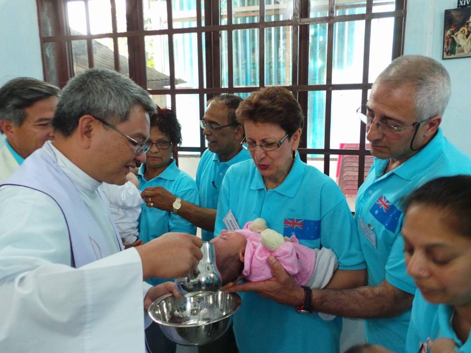 Maria and Vincent Costanzo, above right, who volunteered to be godparents to orphan Vincent Pham (b Nov 23, 2013), pictured in pink, baptised by Fr Vinh Dong. PHOTO: Fr Vinh dong