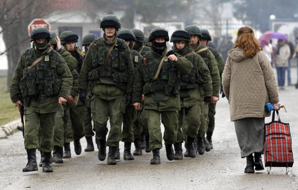 Uniformed men, believed to be Russian servicemen, walk in formation near a Ukrainian military base in Crimea March 7. A Ukrainian Catholic priest in Ukraine's Crimea region said church members are "alarmed and frightened" by the Russian military occupation and fear their communities could be outlawed again if Russian rule becomes permanent. PHOTO: CNS/Vasily Fedosenko, Reuters