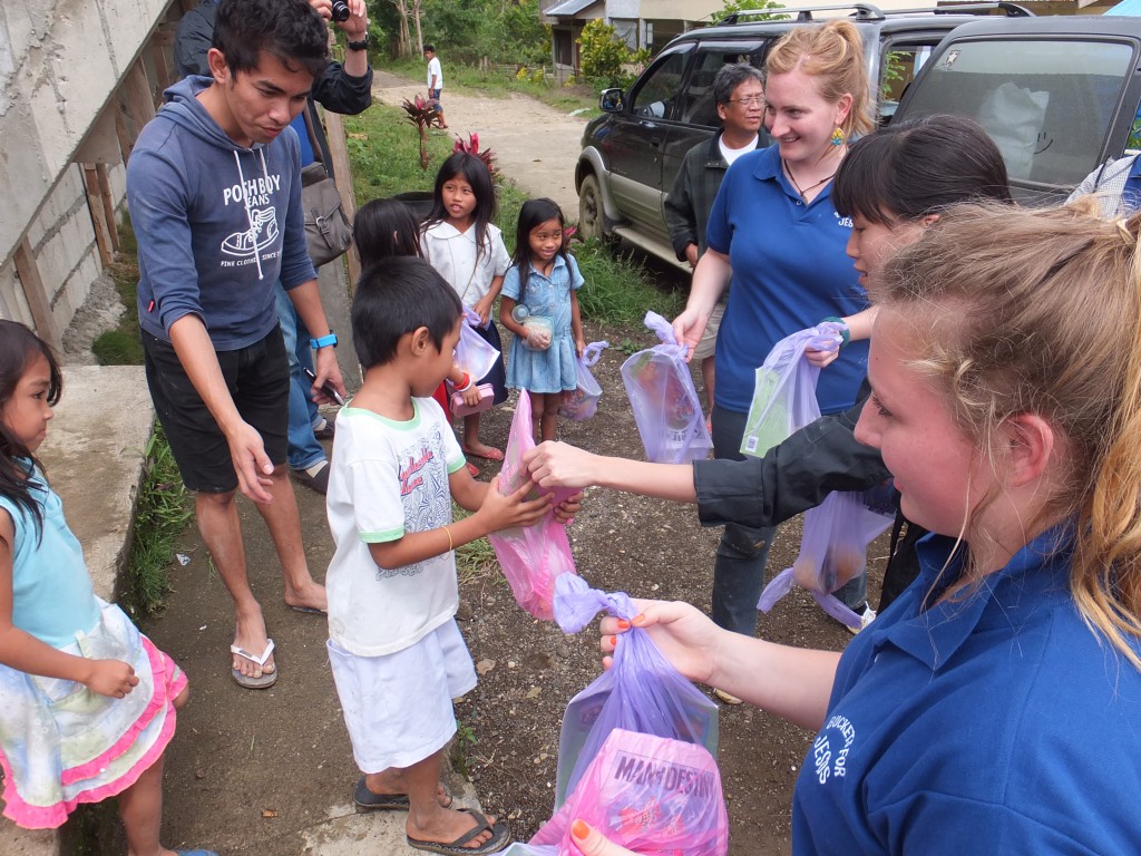 Sarah and Bernadette  Laundy, second from right and right, distributing provisions to children during Buckets For Jesus’ Mission to Bohol, the Philippines, in January 2014. PHOTO: Michael Soh.