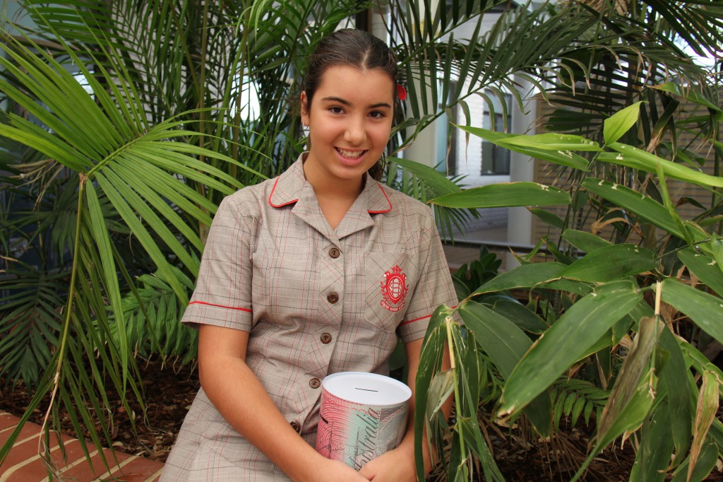 Year 7 Sacred Heart College student, Mia Agostino with the tin full of her pocket money for the past 12 months. Miss Agostino decided to donate the money to Ronald McDonald House after visiting the facility with the college’s Young Vinnies group. 