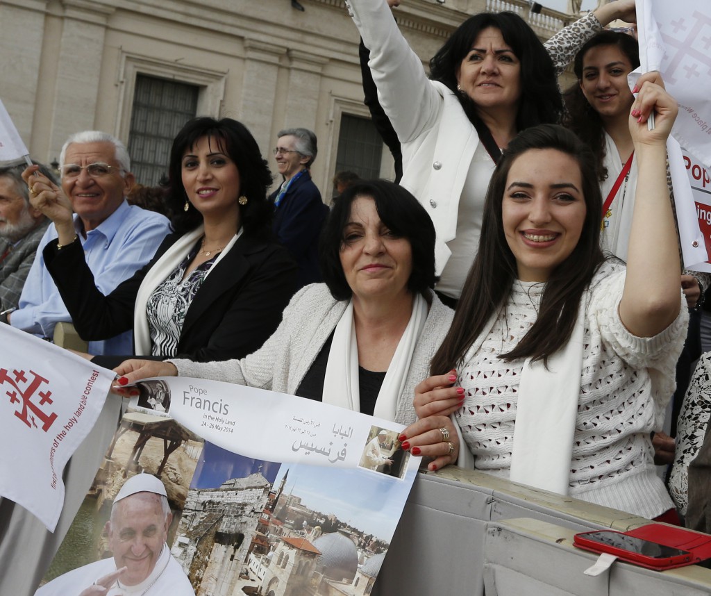 Pilgrims from Nazareth, Israel, hold a poster advertising Pope Francis' May 24-26 trip to the Holy Land as they wait for the pontiff to arrive on April 9 for his general audience in St. Peter's Square at the Vatican. PHOTO: CNS/Paul Haring