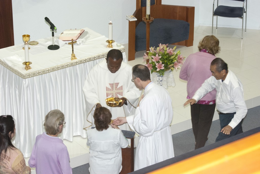 Visiting priest Fr Emmanual Dimobi distributes Holy Communion at All Saints’ Chapel, where two kneelers are in place for communicants. PHOTO: M BIDDLE