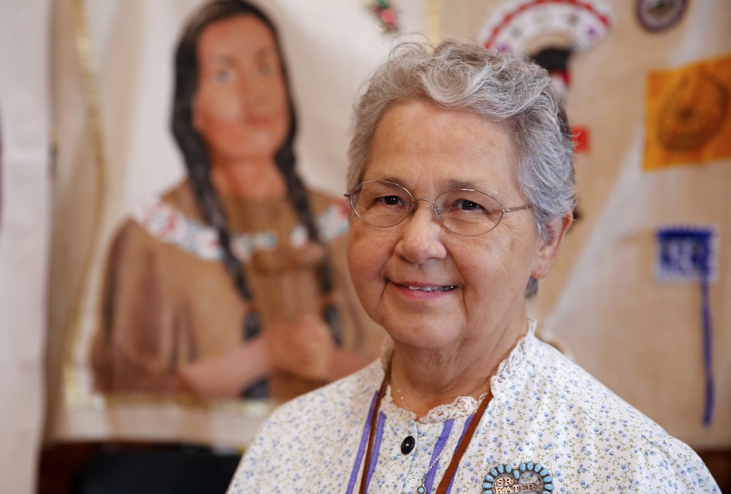 Sister Kateri Mitchell, a Mohawk and a Sister of St. Ann, is the executive director of the Tekakwitha Conference, poses July 26 in front of a banner depicting St. Kateri at the 75th annual Tekakwitha Conference in Fargo, N.D. PHOTO: CNS/Nancy Wiechec