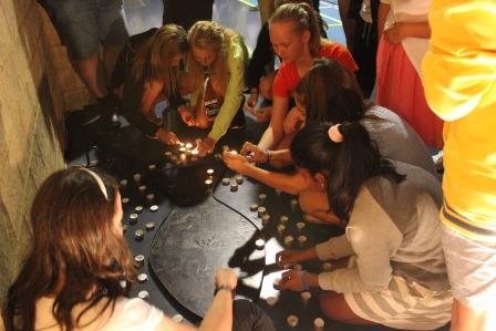 Participants at the Catholic Youth Ministry Stronger Rally light candles and write their prayer intentions on foot-shaped pieces paper. PHOTO: Supplied