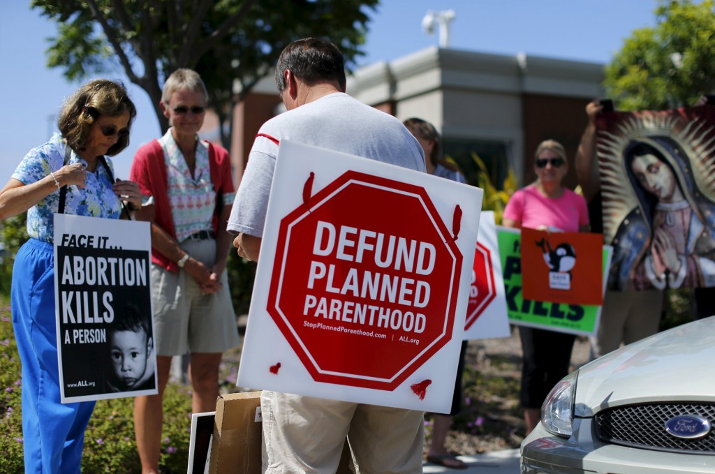 Protesters carry signs and an image of Our Lady of Guadalupe outside a Planned Parenthood clinic in Vista, Calif., Aug. 3. PHOTO: CNS/Mike Blake, Reuters