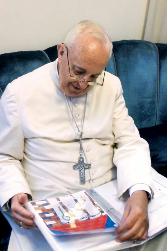 Pope Francis reads one of the letters sent by children around the world. Photo: CNS