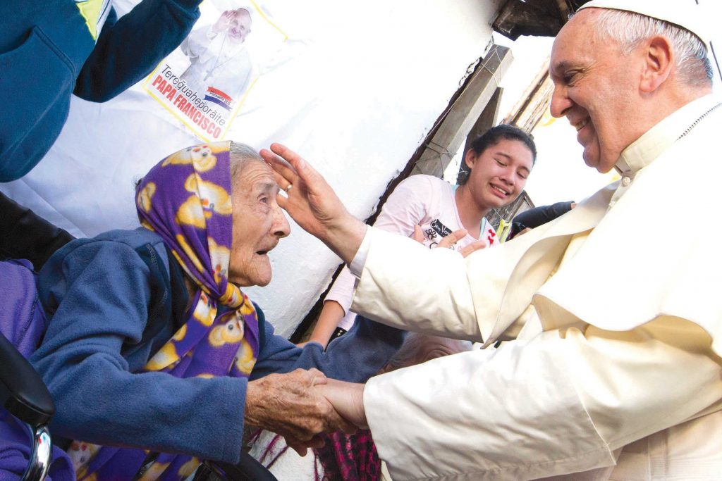 Pope Francis has repeatedly warned against a disposable culture that considers the elderly as a burden on society. Here, he is pictured greeting an elderly woman during a visit to Banado Norte, a poor neighbourhood in Asuncion, Paraguay in 2015. Photo: CNS/Paul Haring