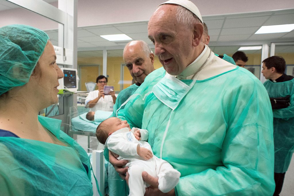 Pope Francis holds a baby as he visits the neonatal unit at San Giovanni Hospital in Rome on 16 September. The visit was part of the Pope's series of Friday works of mercy during the Holy Year. Photo: CNS/L'Osservatore Romano