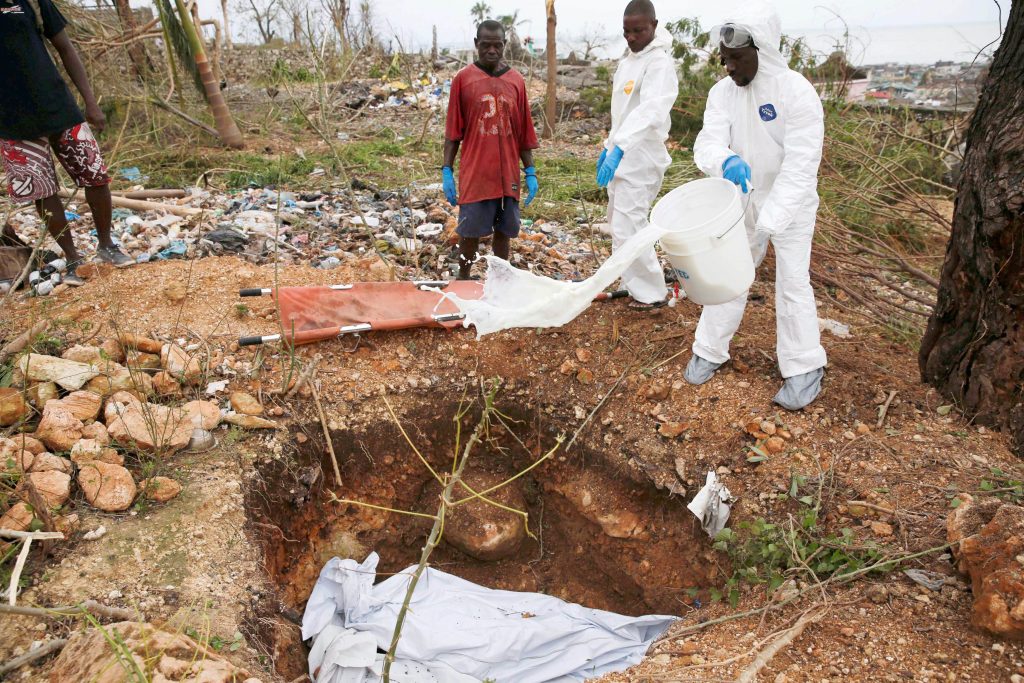 Workers bury bodies on 6 October after Hurricane Matthew passed through Jeremie, Haiti. Rescue workers are struggling to reach parts of Haiti cut off by Hurricane Matthew, the most powerful Caribbean storm in nearly a decade. Photo: CNS /Carlos Garcia Rawlins, Reuters