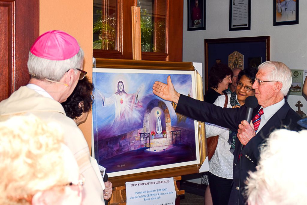 Parishioner of St Francis of Assisi in Maida Vale and talented artist, Tom Hogg, shows Perth Auxiliary Bishop Donald Sproxton his painting “The Grotto of St Francis of Assisi” at the 60-year-anniversary of the parish on 23 October 2016. Photo: Supplied