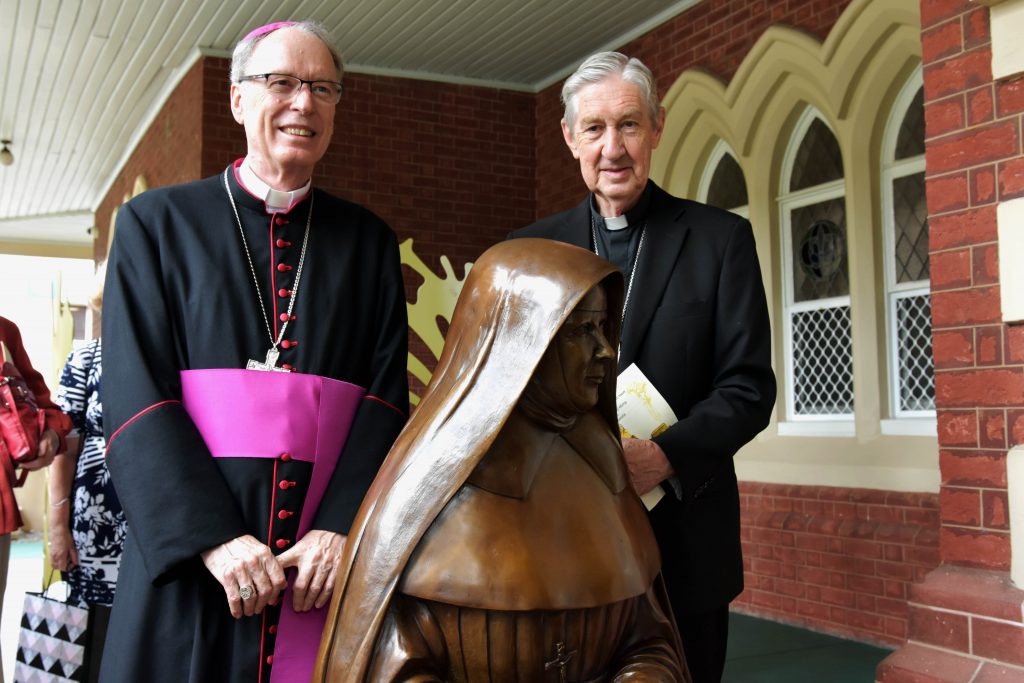 Perth Auxiliary Bishop Don Sproxton (left) and Emeritus Archbishop Barry Hickey (right) stand behind the newly unveiled bronze statue of Ursula Frayne. Photo: Feby Plando