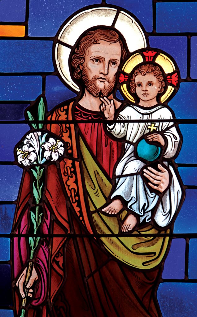 St Joseph, depicted with the infant Jesus in this stained-glass window, remains an important role model for husbands and fathers today. Photo: CNS/Gregory A. Shemitz