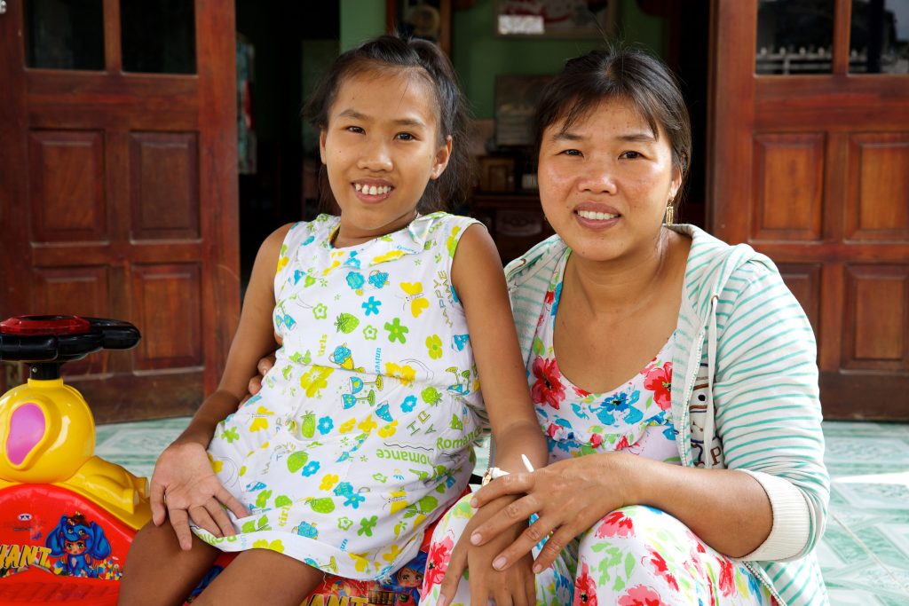 Nguyet with her mum Tim outside their home. Photo: Richard Wainwright/Caritas Australia