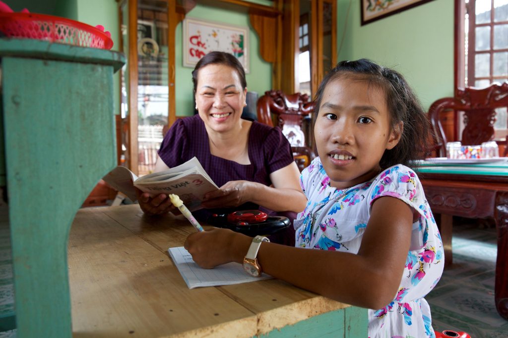 Nguyet during a literacy class with her teacher Quynh. Photo: Richard Wainwright/Caritas Australia