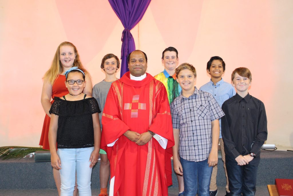 Year seven student from Kolbe Catholic College, Jordan Smith, Jacob Stent, Alicia Hutchison, Lani Tionisio, Liam Cox, Peter Wickham and Alexander Lanzafame, joined the congregation to passionately present the readings, the Responsorial Psalm and together with Fr Vijay, assisted with the Gospel reading of the Passion. Photo: Supplied