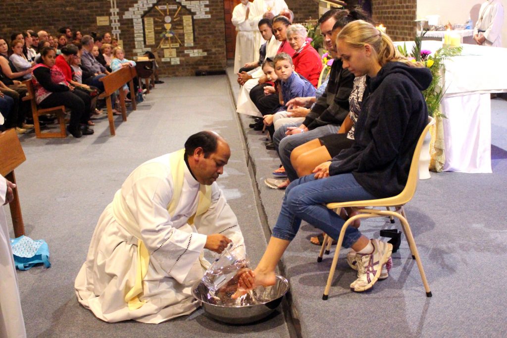 Fr Vijay washing the feet of parishioners at the start of the Easter Triduum on Maundy Thursday. Photo: Supplied