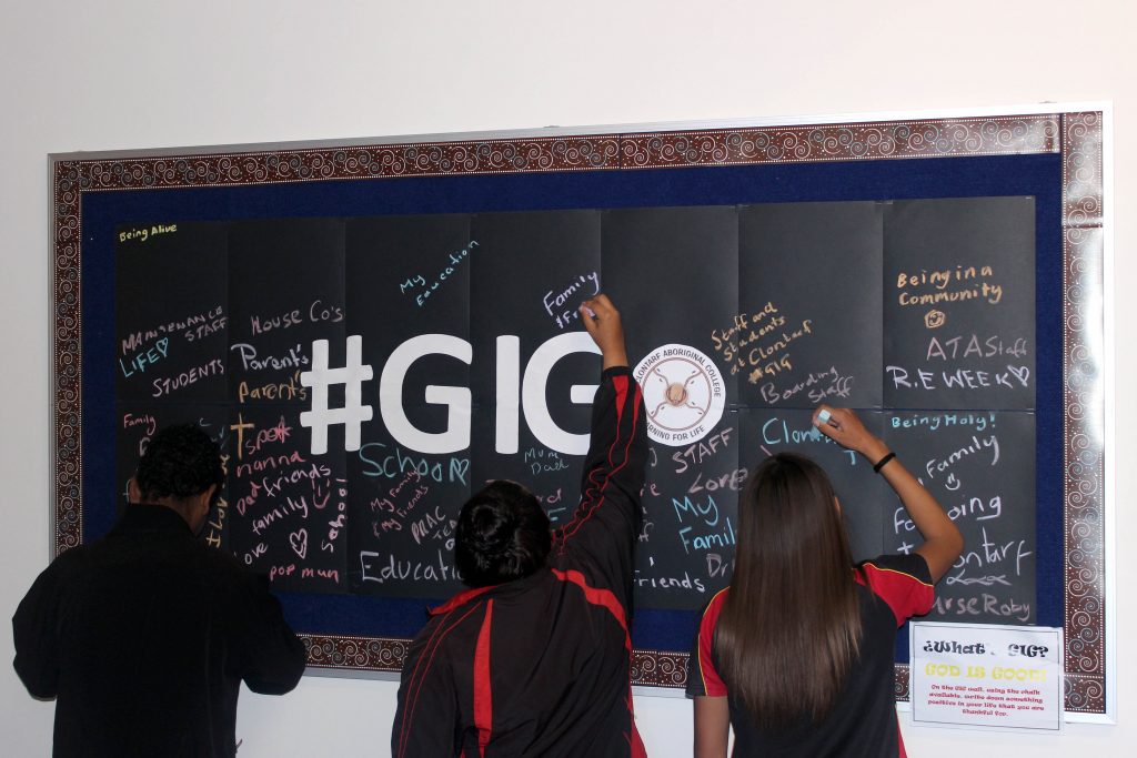 Students write on the interactive #GIG wall where they had the opportunity to write what they are thankful for in their lives. Photo: Supplied.