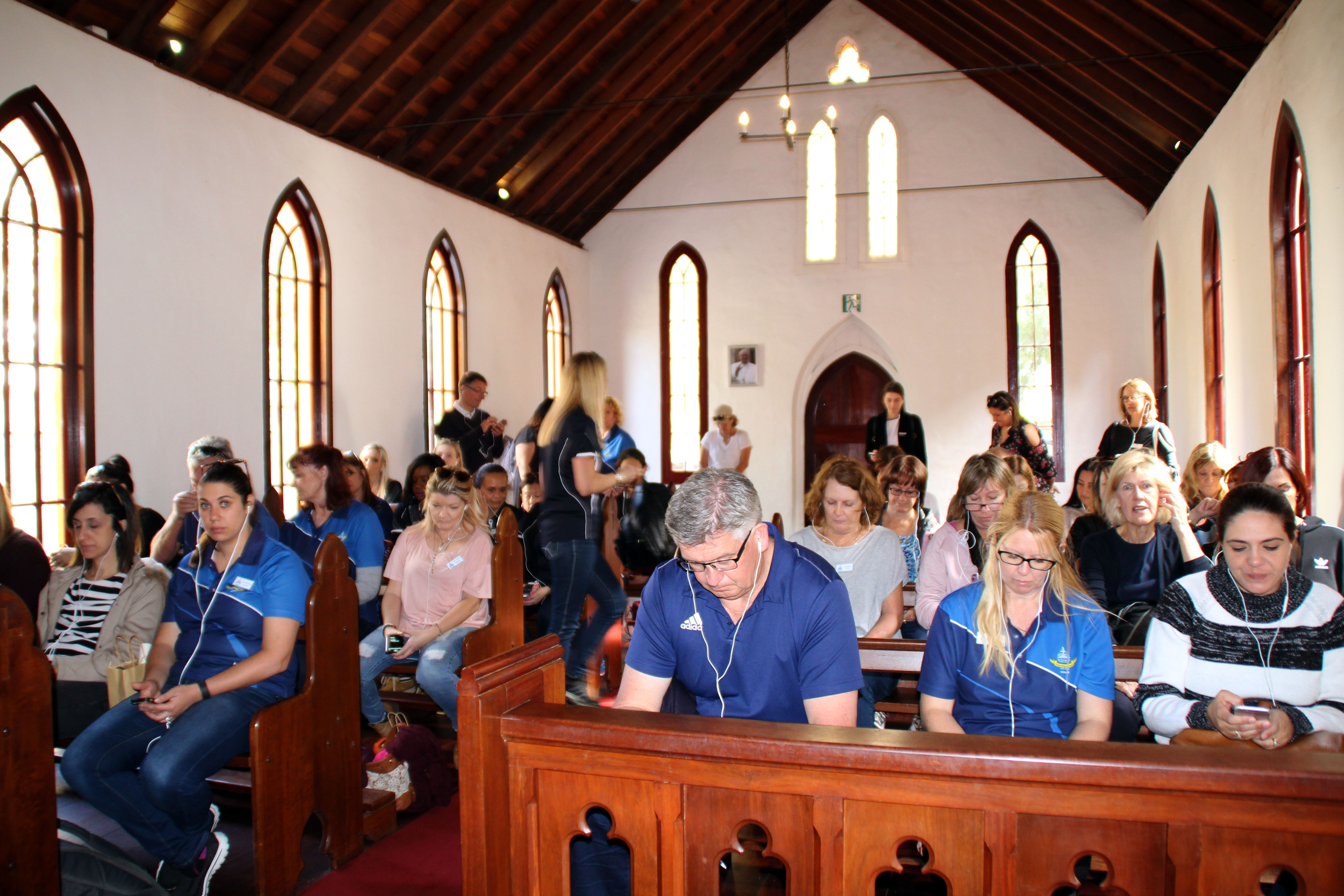 Staff from both schools listen to an audio track in the Pro-Cathedral. Photo: Supplied.