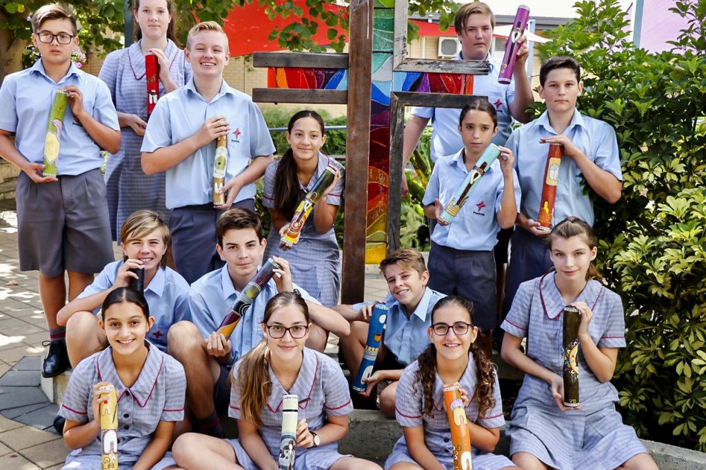 Prendiville College students proudly display the Message Sticks Photo: Prendiville Catholic College.