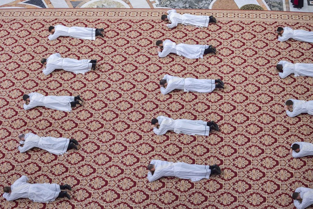 Candidates for the priesthood lie prostrate during an ordination Mass celebrated by Pope Francis in St Peter's Basilica at the Vatican on 12 May 2019. The Holy Father ordained 19 new priests. Photo: Stefano Spaziani/CNS.